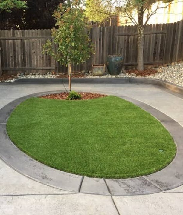 Circular artificial lawn installation framed by concrete