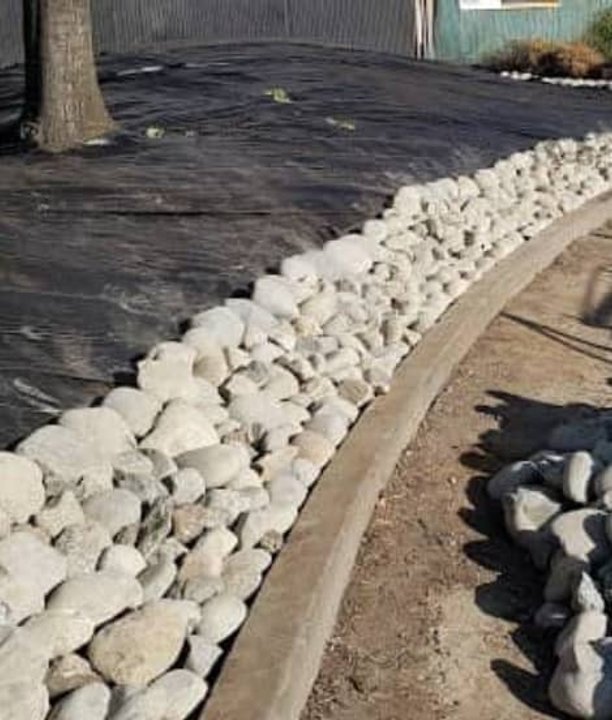 Rock border installation alongside fresh mulch and dirt