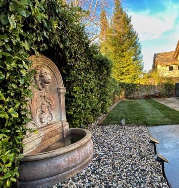 Decorative garden fountain surrounded by manicured greenery