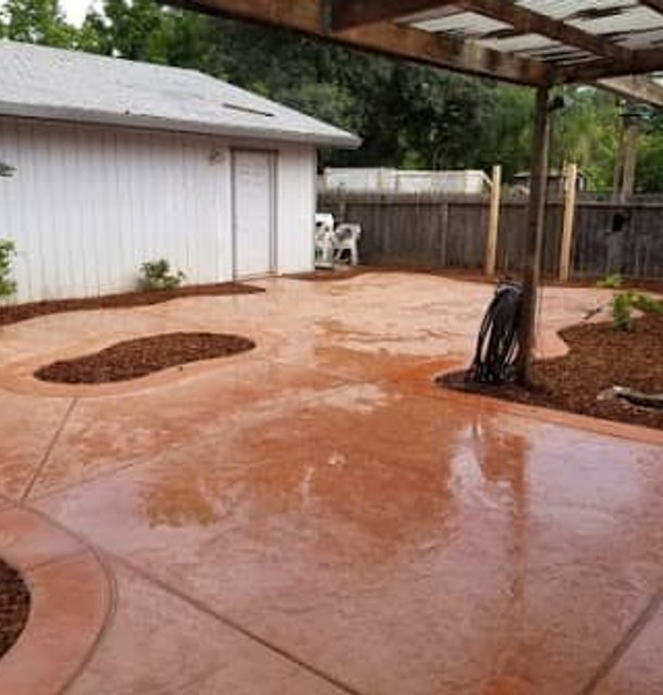 Stamped concrete patio with curved edges and garden beds