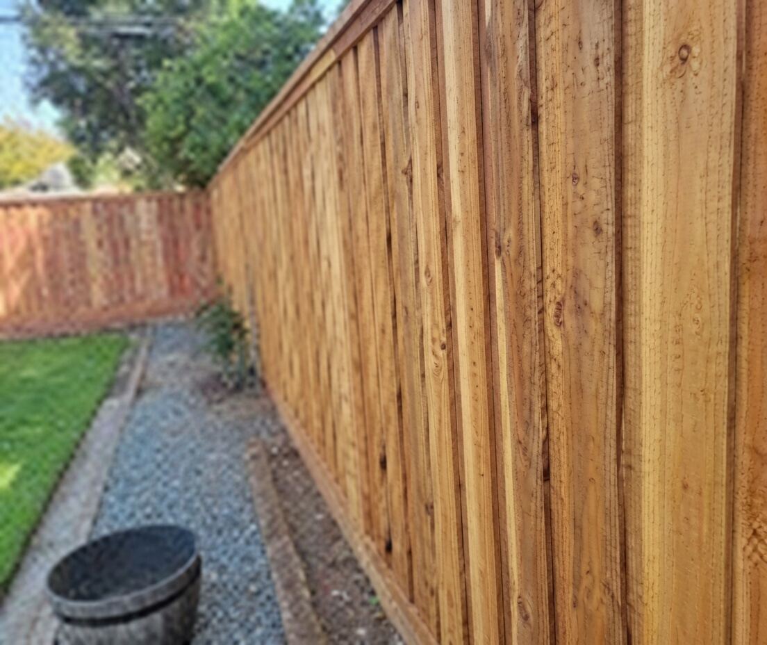New cedar privacy fence with clean gravel side yard