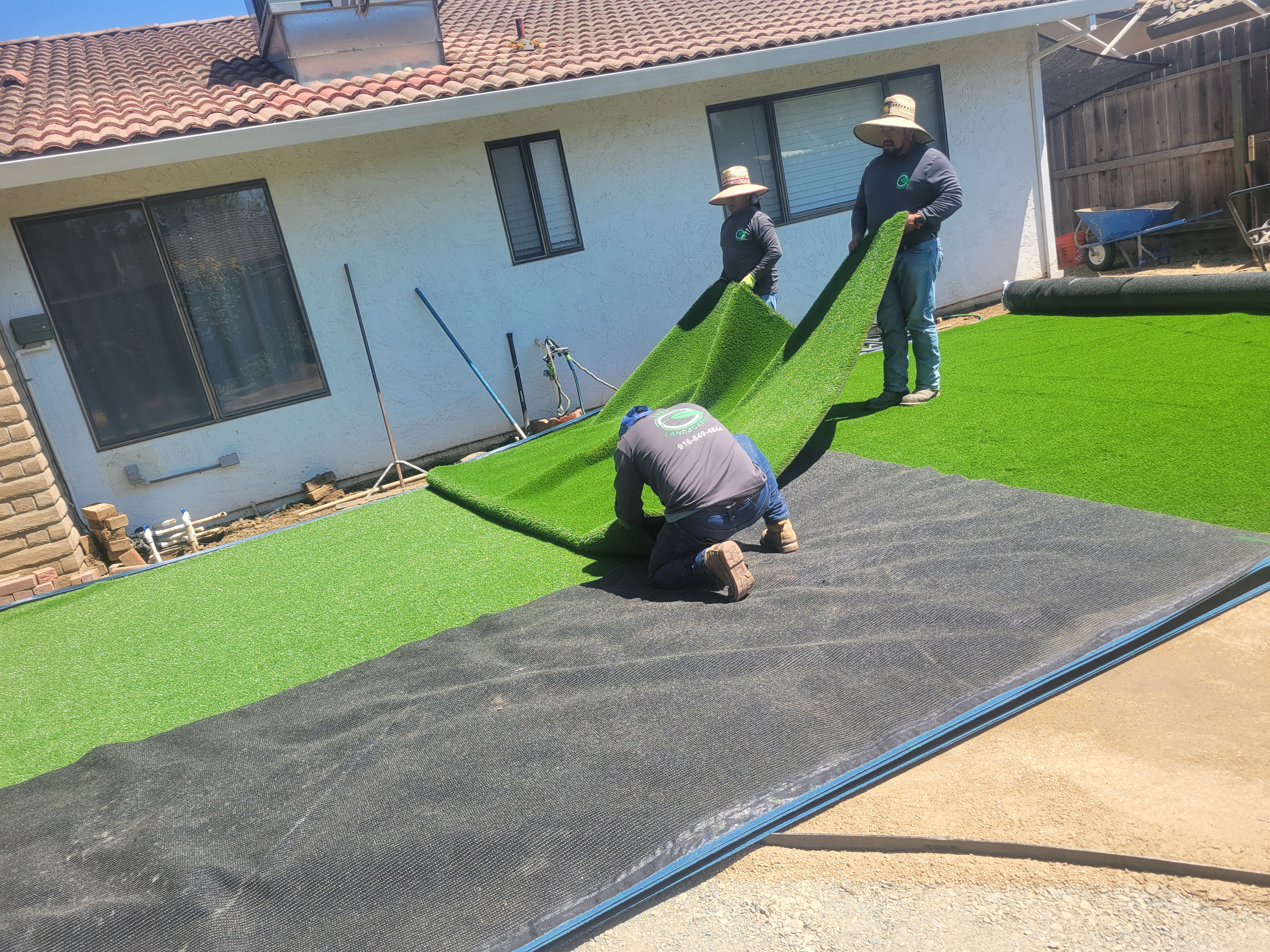 Green Landscaping crew installing artificial turf Sacramento