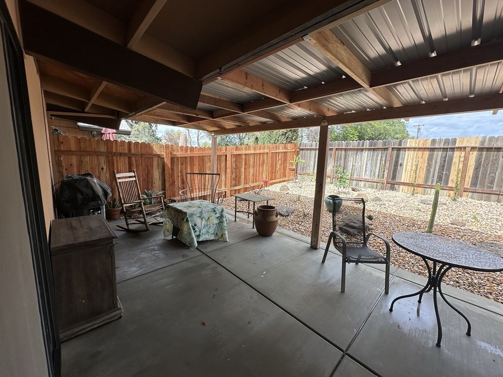Covered patio with decorative rock and palm